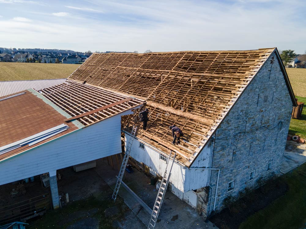 men working on a barn roof